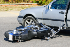 traffic accident, motorcycle collision with a car on city street